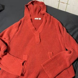 Orange v-neck sweater.